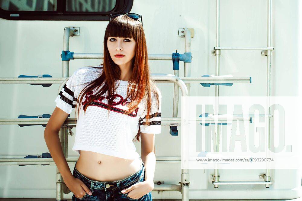 Portrait attractive women in sports white T-shirt against background of Camper Trailer, transport for travel,model released, Symbolfoto