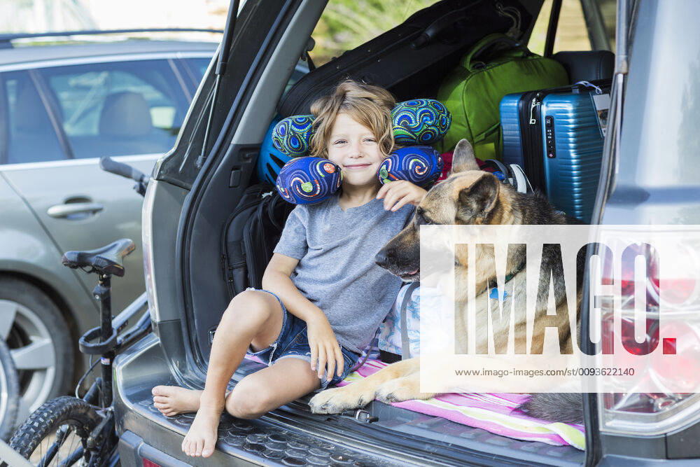 IMAGO Creative: Reisen mit Haustier 5 year old boy with his German Shepherd dog, in back of SUV 5 year old boy with his German Shepherd dog, in back of SUV 58559
