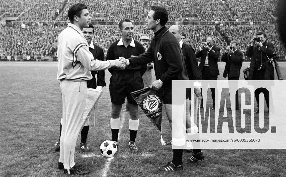 Länderspiel in Stuttgart - BR Deutschland - Österreich 4:1 - Die Spielführer Johann Buzek (Österreich, li.) und Torwart Hans Tilkowski (BRD) tauschen die Wimpel vor Schiedsrichter Gottfried Dienst (Schweiz)