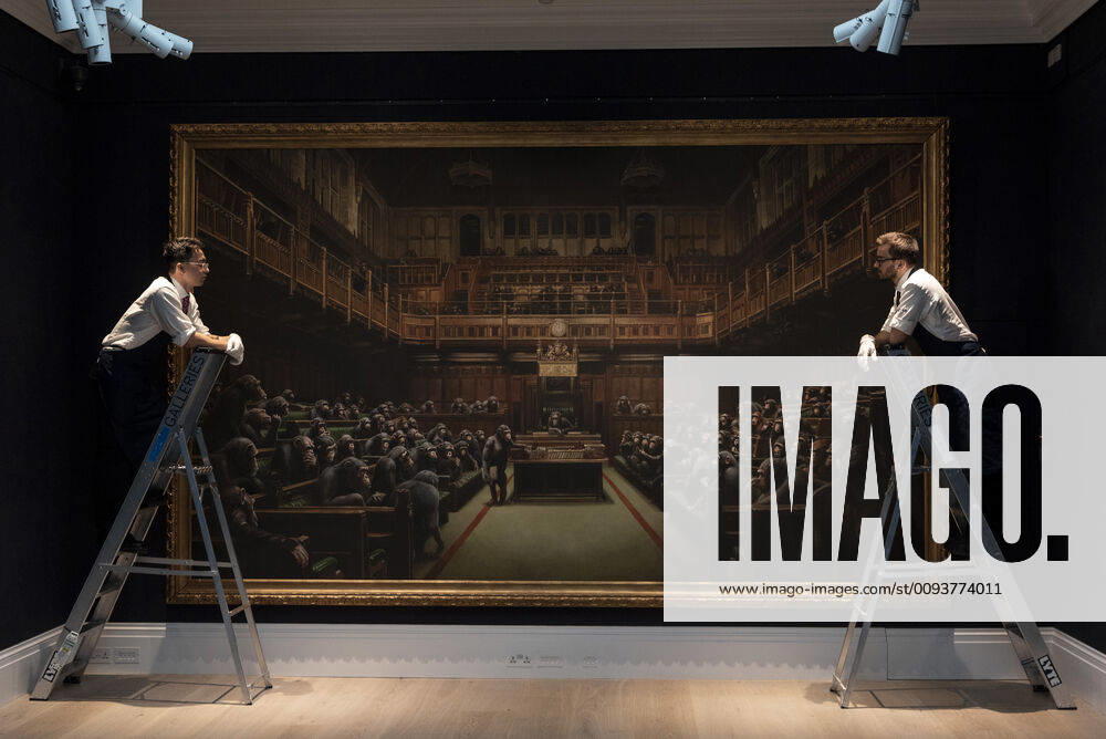 London, UK. Sotheby s staff hold a painting titled Devolved Parliament, 2009, by artist Banksy. The painting depicts MP s in the houses of Parliament with an estimate of £1.5-2 million. The work is part of the Sotheby s contemporary art auction. London UK - ZUMAl94_ 20190927_zaf_l94_005