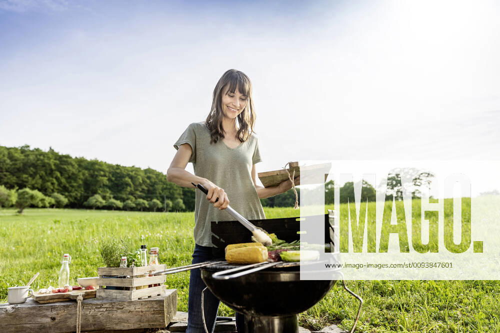 Smiling woman preparing vegetable on barbecue grill model released Symbolfoto property released FMKF05795