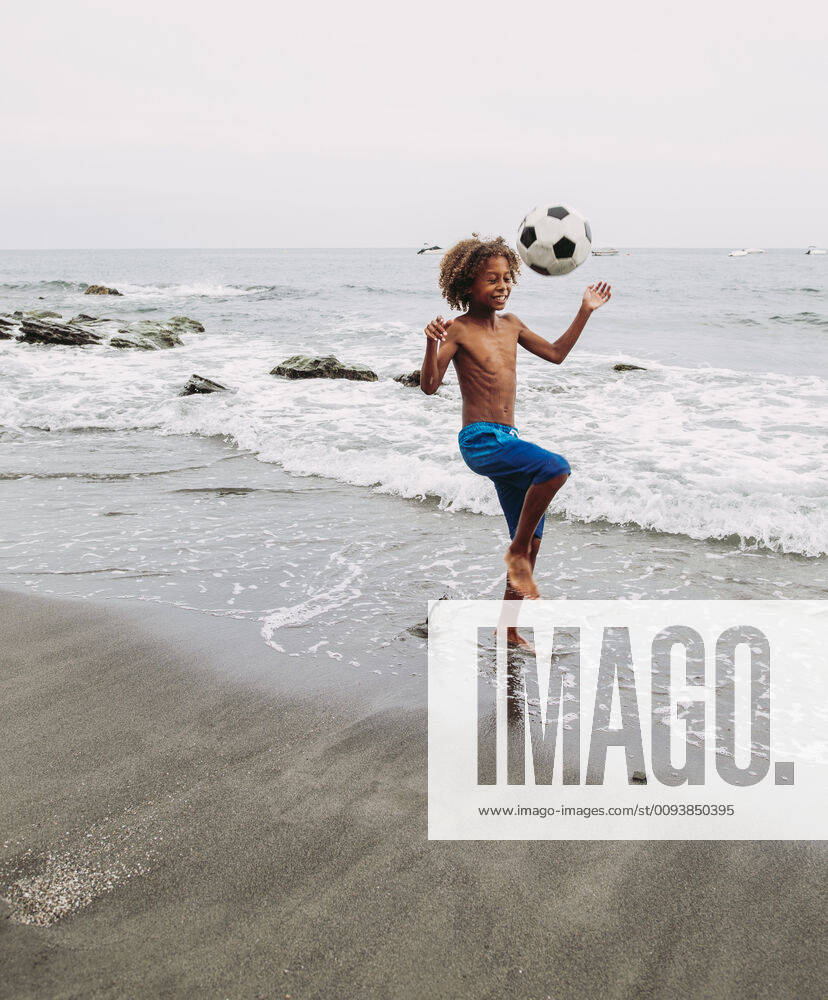 Freizeit Trend: Football Freestyle Boy playing with a football on the beach model released Symbolfoto LJF00988