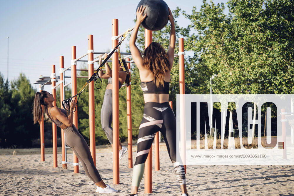 Three young women doing workout on calisthenics bars model released Symbolfoto OCMF00557