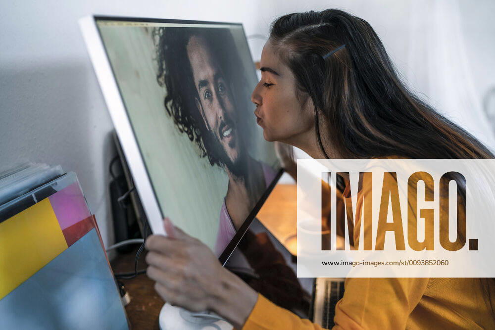 Young woman kissing man on computer screen model released Symbolfoto property released RIBF01052