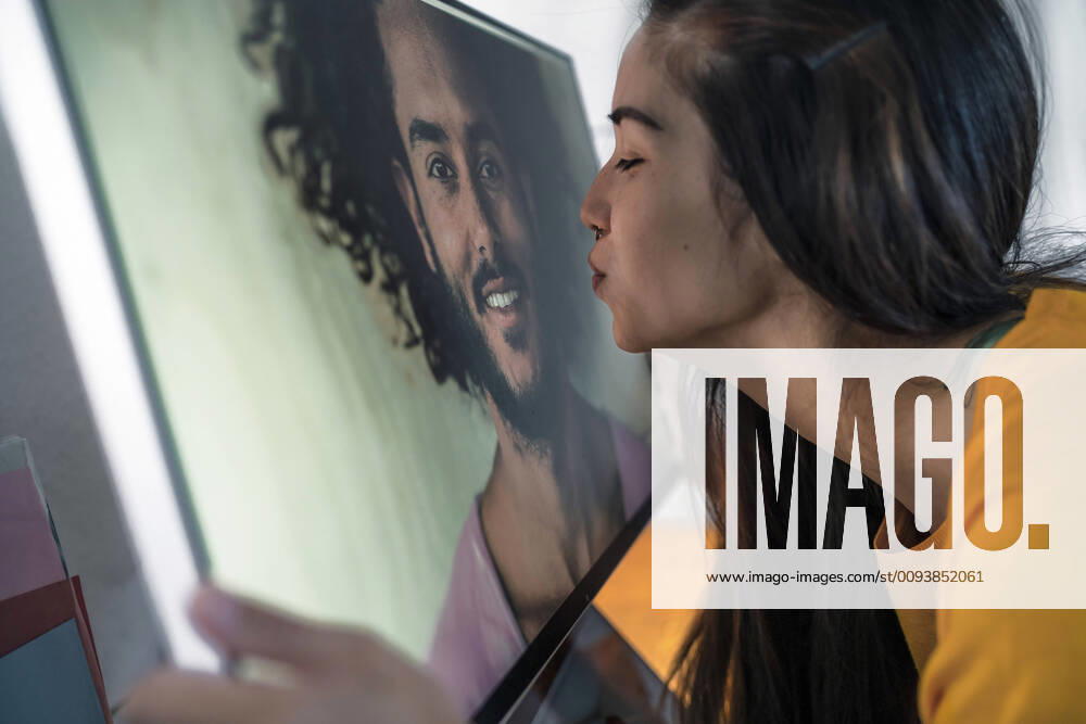 Young woman kissing man on computer screen model released Symbolfoto property released RIBF01053