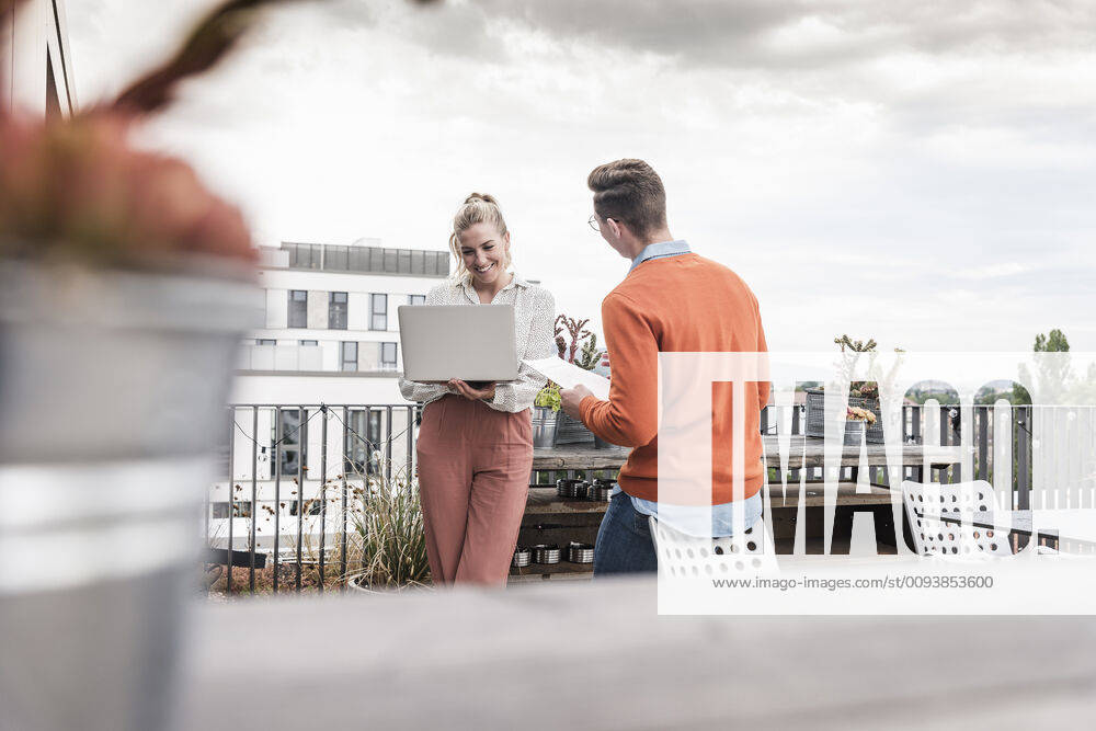 Casual businessman and woman with laptop meeting on roof terrace model released Symbolfoto property released UUF18550