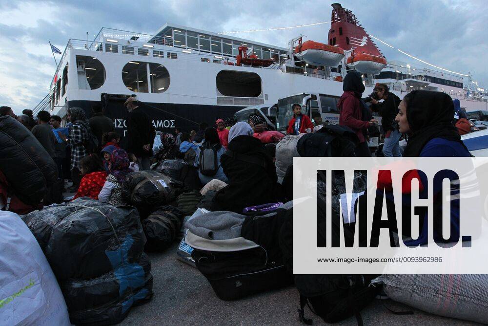Refugees and migrants wait with their belongings after disembarking from a ferry at the port of Piraeus, near Athens . Migrants and refugees arrive at the port of Piraeus from the island of Lesbos as authorities have accelerated efforts to move thousands of migrants deemed to be vulnerable from the overcrowded Moria camp to camps on the mainland. Piraeus Greece - ZUMAv62_ 20191007_zaf_v62_033