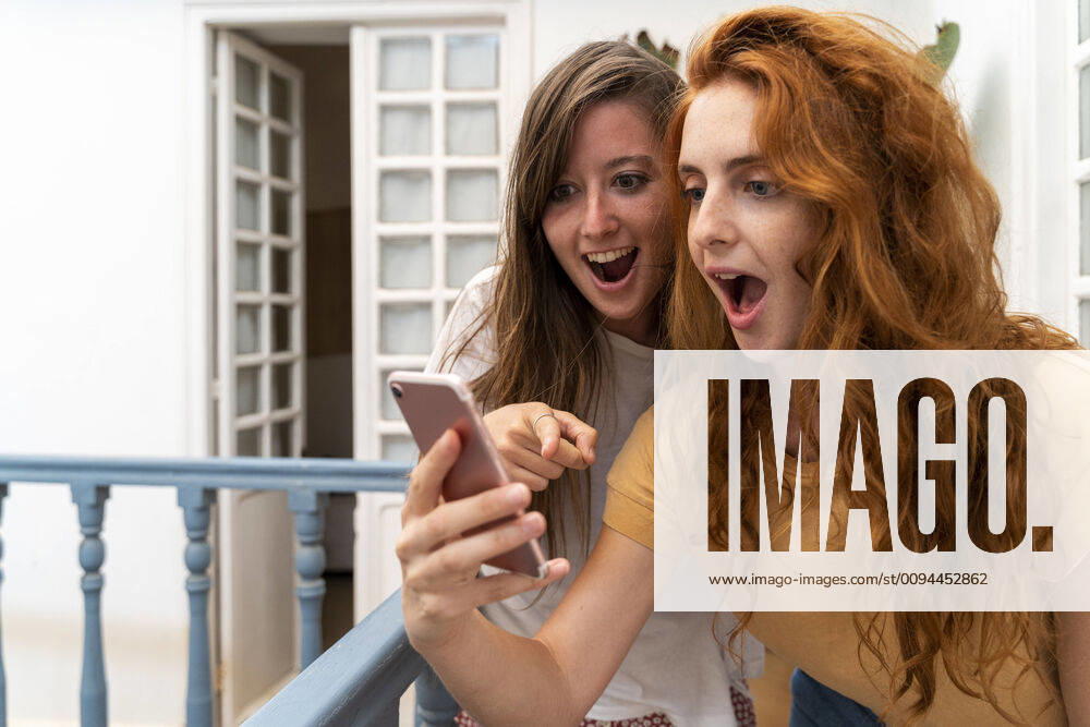 Portrait of two excited friends looking at smartphone model released Symbolfoto AFVF03961
