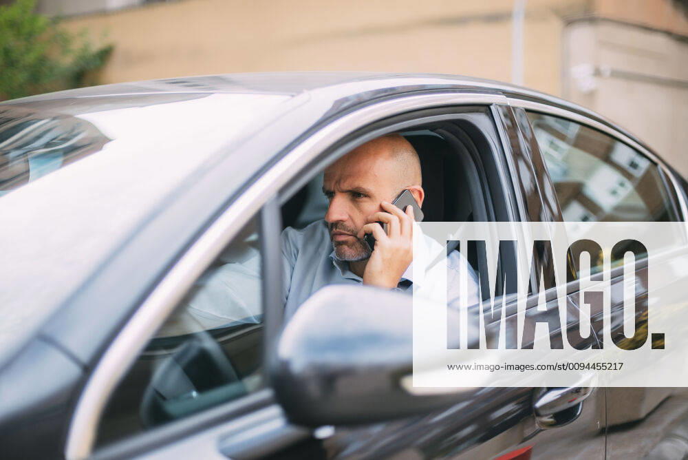 Businessman driving vehicle and using smartphone model released Symbolfoto CJMF00080