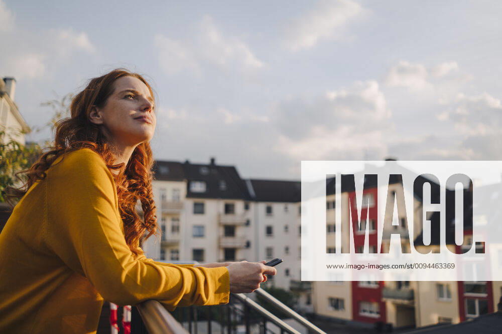 Redheaded woman standing on roof terrace model released Symbolfoto property released KNSF06618