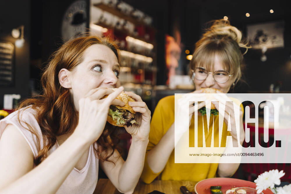 Food, Fast Food, Burger Two female friends eating burger in a restaurant model released Symbolfoto property released KNSF06664