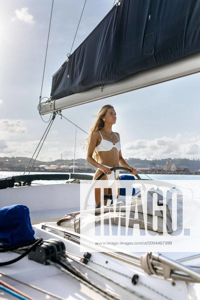 Young woman navigating catamaran on a sailing trip model released Symbolfoto MGOF04161