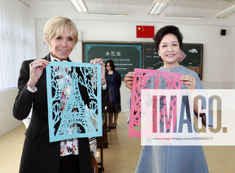 (191105) -- SHANGHAI, Nov. 5, 2019 -- Peng Liyuan, wife of Chinese President Xi Jinping, and Brigitte Macron, wife of French President Emmanuel Macron, show paper-cutting works during a class of traditional handicrafts at the Shanghai Foreign Language School affiliated to Shanghai International Studies University in Shanghai, east China, Nov. 5, 2019. Peng Liyuan invited Brigitte Macron to visit the middle school on Tuesday. ) (CIIE)CHINA-SHANGHAI-PENG LIYUAN-FRENCH FIRST LADY-MIDDLE SCHOOL-VISIT (CN) DingxLin