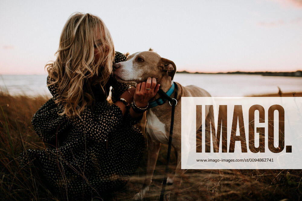 Woman and dog on the beach at sunset United States, Connecticut, Fairfield CR_KRMI191018-219250-01