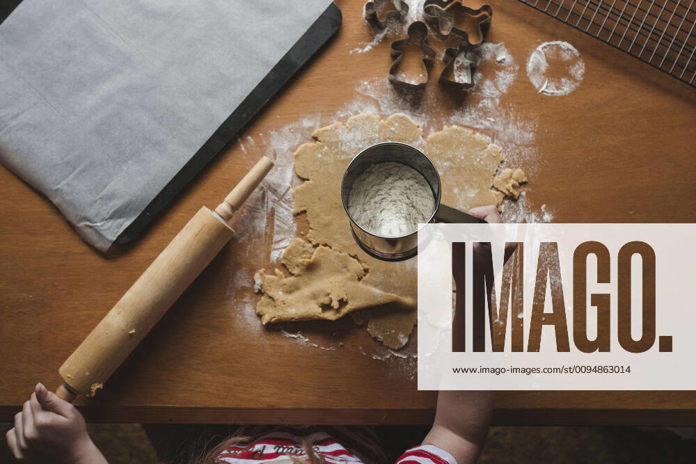 Young girl sifting flour on gingerbread dough New Zealand, Taranaki, Hawera CR_LVBS191016-207946-01