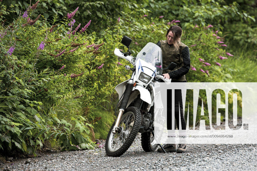 IMAGO Creative: Internationaler Frauenmonat, Gesundheit, Frauen in der Menopause A women takes a break from motorcycle riding and stands with her bike. Canada, British Columbia, Pemberton CR_PSFZ191008B-161888-01