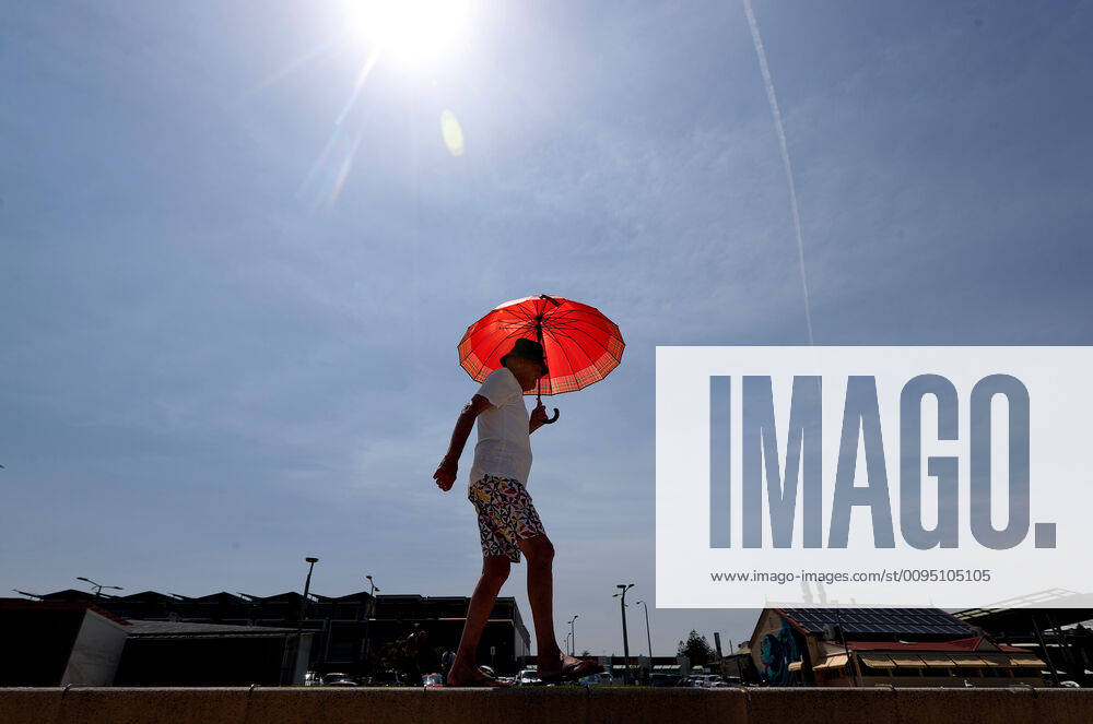 HOT WEATHER ADELAIDE, A man walks with an umbrella at Henley Beach during hot weather in Adelaide, Wednesday, November 20, 2019. More than 100 schools will be closed in South Australia today, as much of the state braces for catastrophic fire danger conditions. ( NO ARCHIVING, , NO USE IN BOOKS WITHOUT CONSENT ADELAIDE SA AUSTRALIA