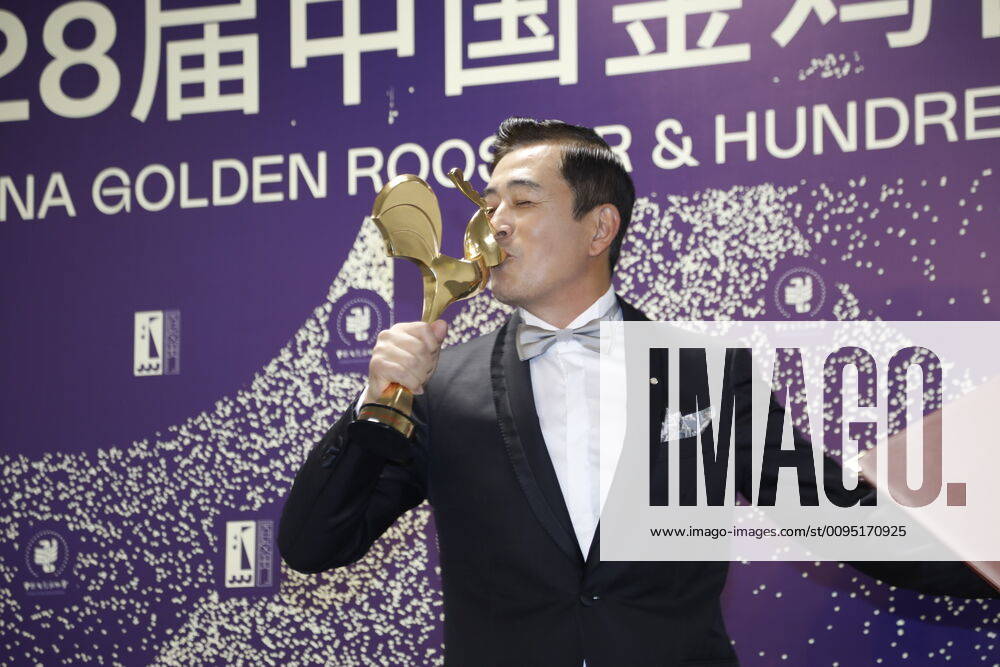 Actor Wang Zhifei kisses his trophy backstage during the closing ceremony of the 28th China Golden Rooster And Hundred Flowers Film Festival on November 23, 2019 in Xiamen, Fujian Province of China.
