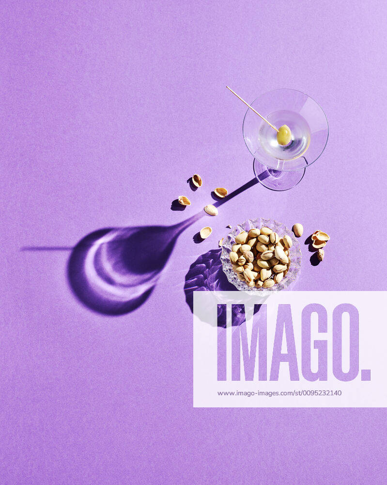 Directly above shot of pistachios and martini glass with shadow on purple background KSWF02073