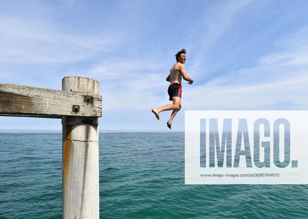ADELAIDE HOT WEATHER, A swimmer jumps from the Port Noarlunga Jetty in Adelaide, Tuesday, December 17, 2019. A heatwave spreading across Australia is expected to see parts of the nation swelter through temperatures close to 50C. ( NO ARCHIVING, , NO USE IN BOOKS WITHOUT CONSENT ADELAIDE SA AUSTRALIA