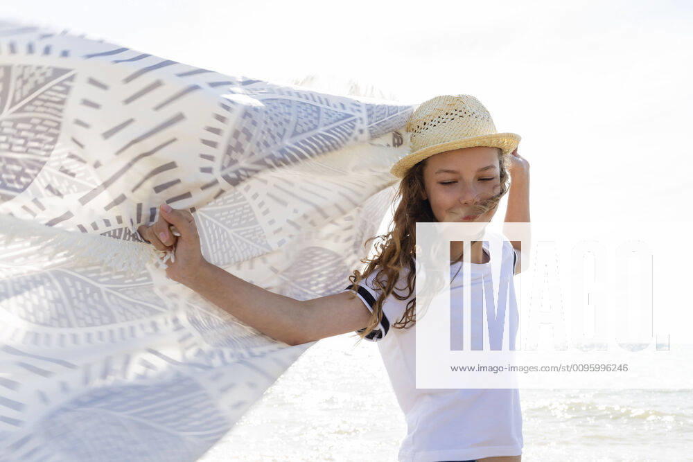 Smiling girl with towel on the beach, Tuscany, Italy model released Symbolfoto OJF00355