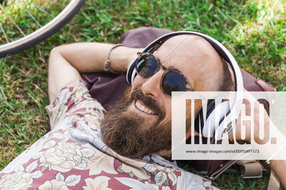 Mature man with red basecap, sunglasses and white headphones model released Symbolfoto TCF06228