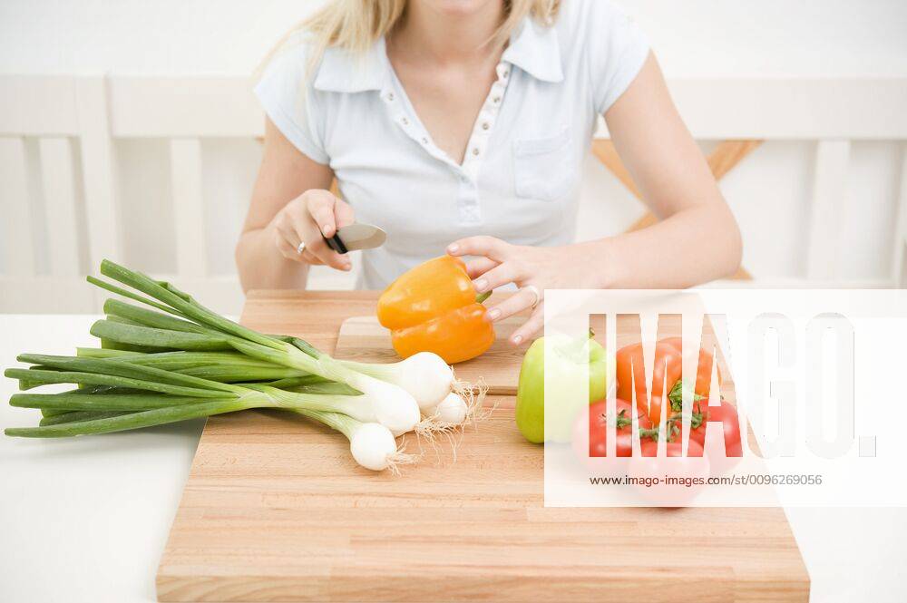 Woman slicing vegetables in the kitchen Woman slicing vegetables in kitchen