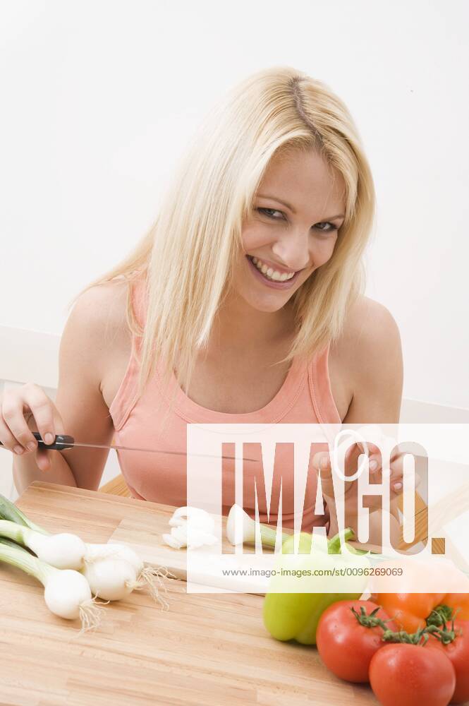 Woman slicing vegetables in the kitchen Woman slicing vegetables in kitchen