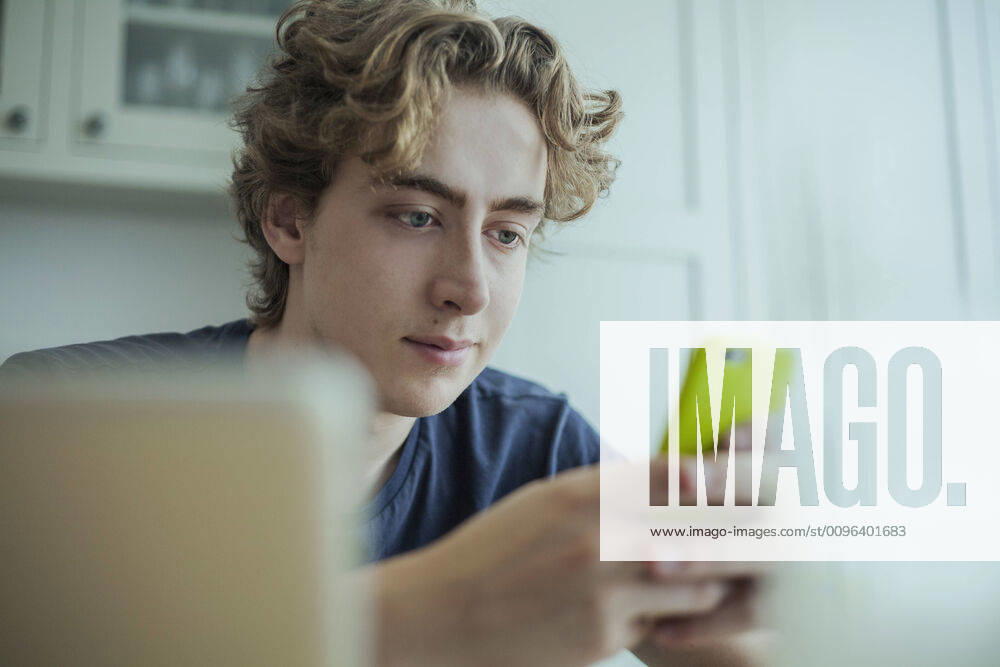Young man using smartphone at home model released Symbolfoto property released AJOF00081
