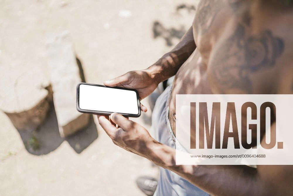 Young man during workout, holding smartphone model released Symbolfoto FBAF01214