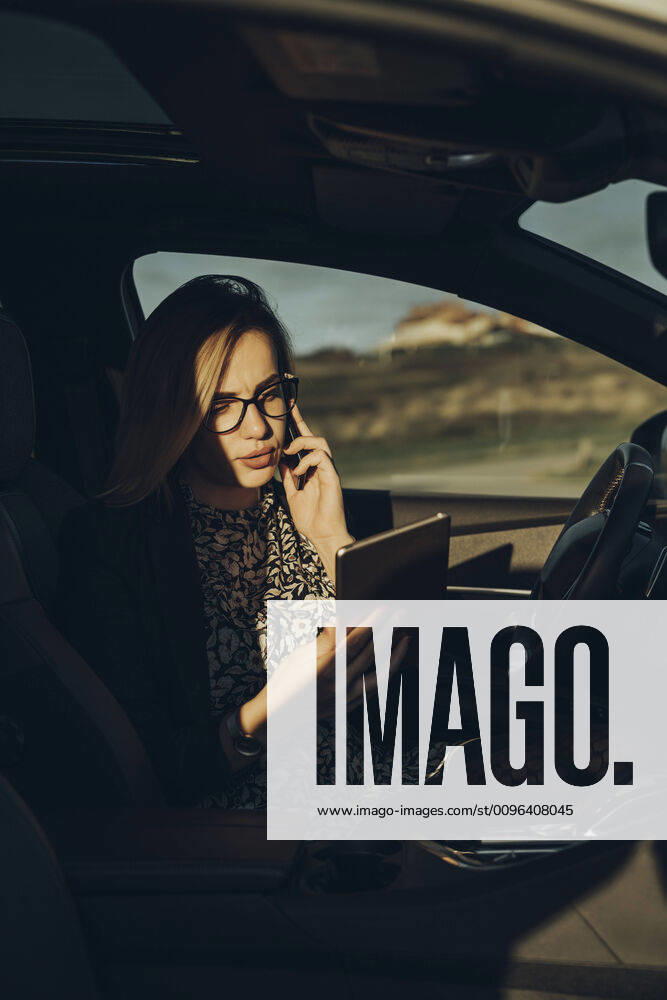 Young blond woman using smartphone and tablet in the car model released Symbolfoto MTBF00311