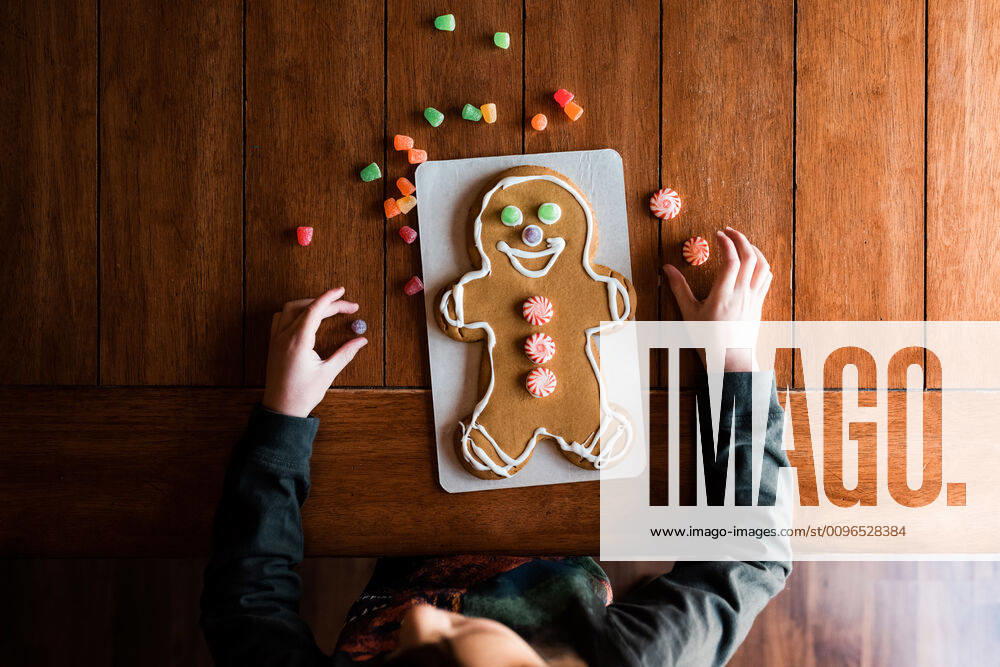 Small kid decorating a gingerbread man on the kitchen table Marshalltown, IA, United States CR_KAVO191211-258389-01