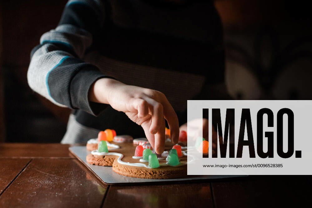 IMAGO Creative: Kimawandel - Weihnachten, Weihnachtsessen vegan small hands touching a gumdrop on a gingerbread man cookie on table Marshalltown, IA, United States CR_KAVO191211-258390-01