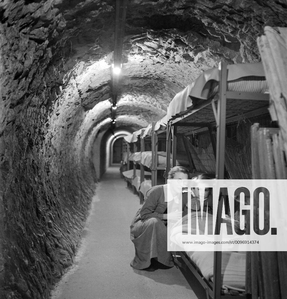 Woman kneeling next to bed of child in Underground Tunnel during World War II Bombing of London, England, UK, photograph by Toni Frissell, January 1945 London England, UK - ZUMAg145 20171208_zza_g145_033