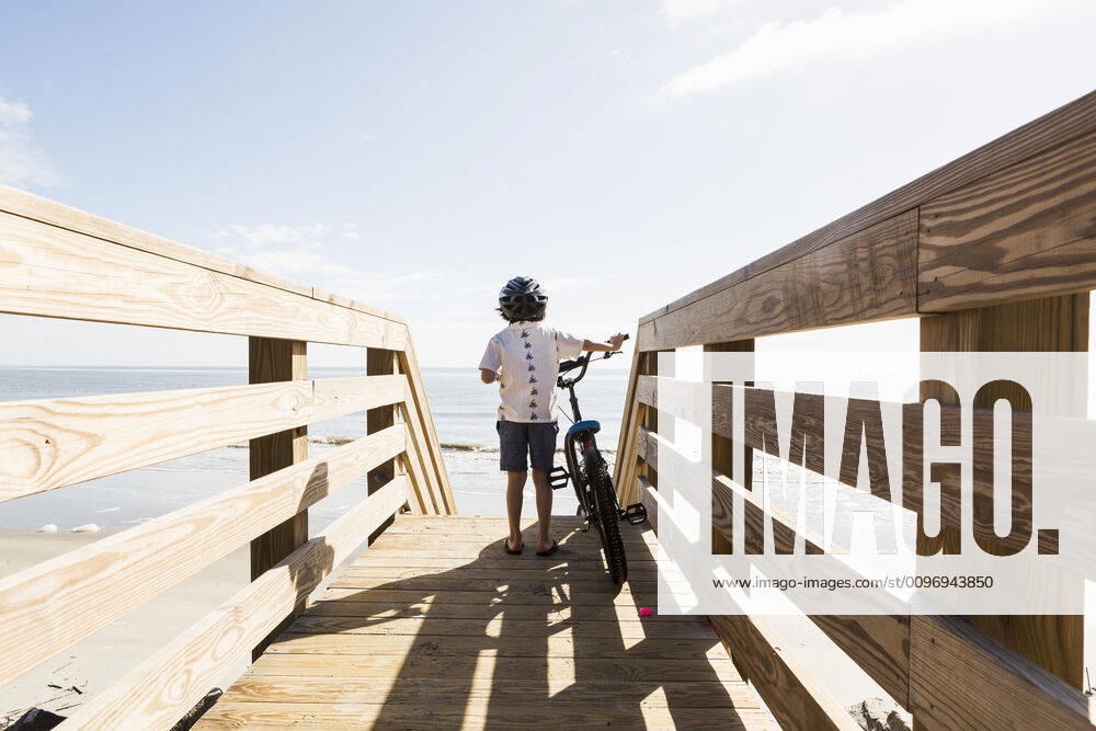 IMAGO Creative: Sommer Sport - Strand 6 year old boy on wooden bridge with his bike 6 year old boy on wooden bridge with his bike,St Simon s Island 61037