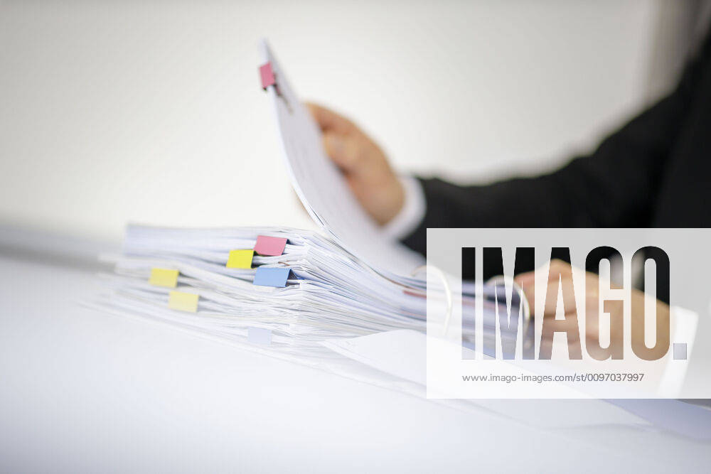 Symbol photo A man leafs through a file folder with documents lying on a table Berlin, 18 02 2020 Berlin Germany