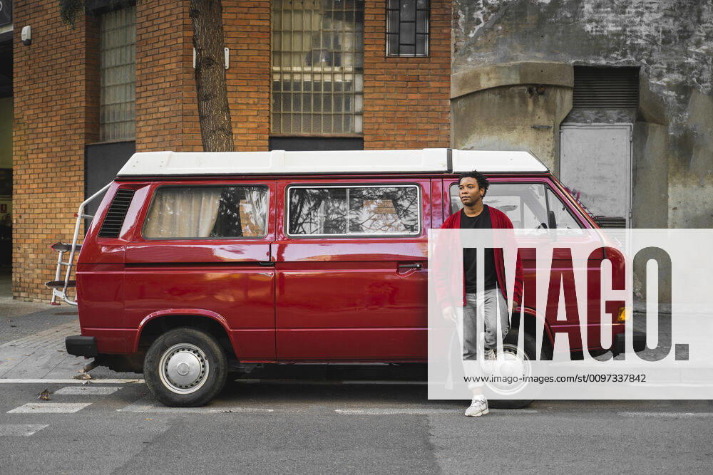 Mature man leaning at reed Volkswagen Transporter parked at roadside model released Symbolfoto AFVF05240
