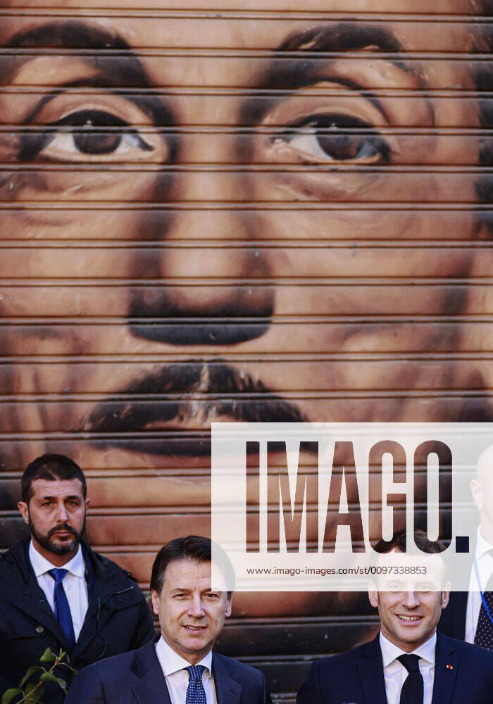 French President Emmanuel Macron, visiting Naples for the Italian-French summit, arrives at the San Ferdinando theater with the Italian Prime Minister, Giuseppe Conte. Behind them a mural of the famous Italian playwright Eduardo De FIlippo.