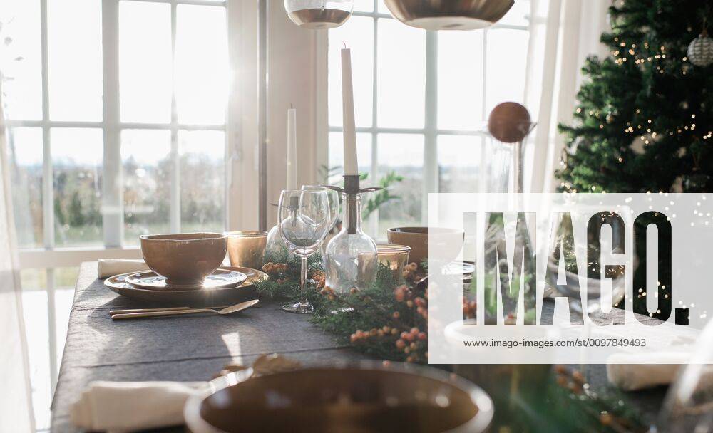 IMAGO Creative: Landleben - Essen tall candles on a decorated dinner table at home at Christmas Norrto¤lje, Stockholm County, Sweden CR_RABE200115-271811-01