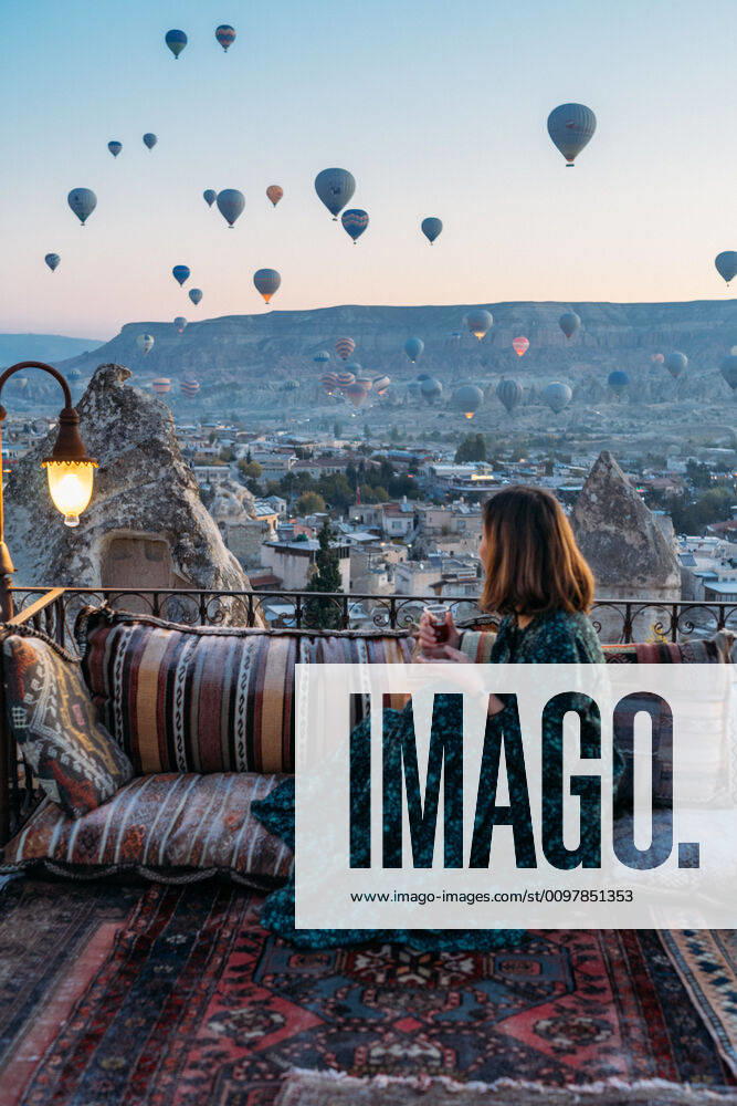 Woman drinking early morning tea with hot air balloons in Cappadocia Go¶reme, NevAÂüehir, Turkey ,model released, Symbolfoto CR_SEAK200116B-287289-01
