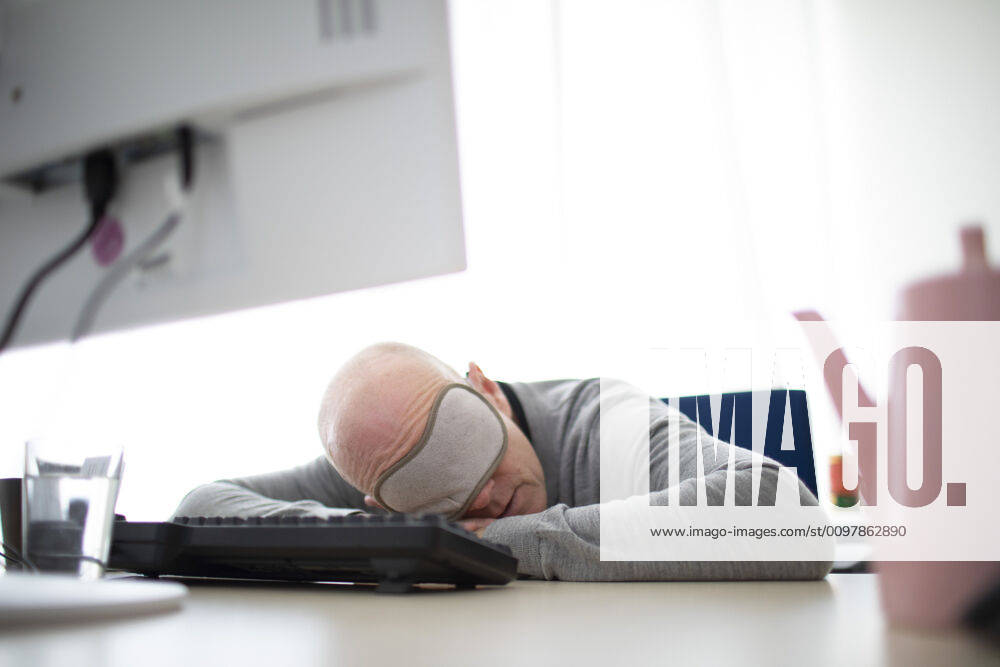 Photo presented on the subject of naps in the office, Bonn, den 11 03 2020 A man with a sleep mask sleeps on his desk Bonn Germany