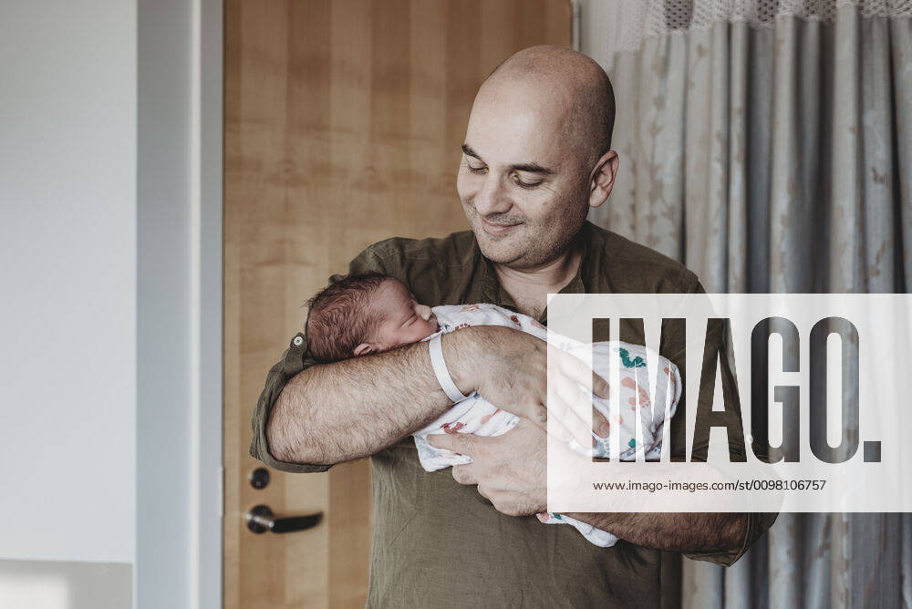 Happy father holding newborn boy wrapped in blankets in hospital San Diego, CA, United States ,model released, Symbolfoto CR_KESM200220-261060-01