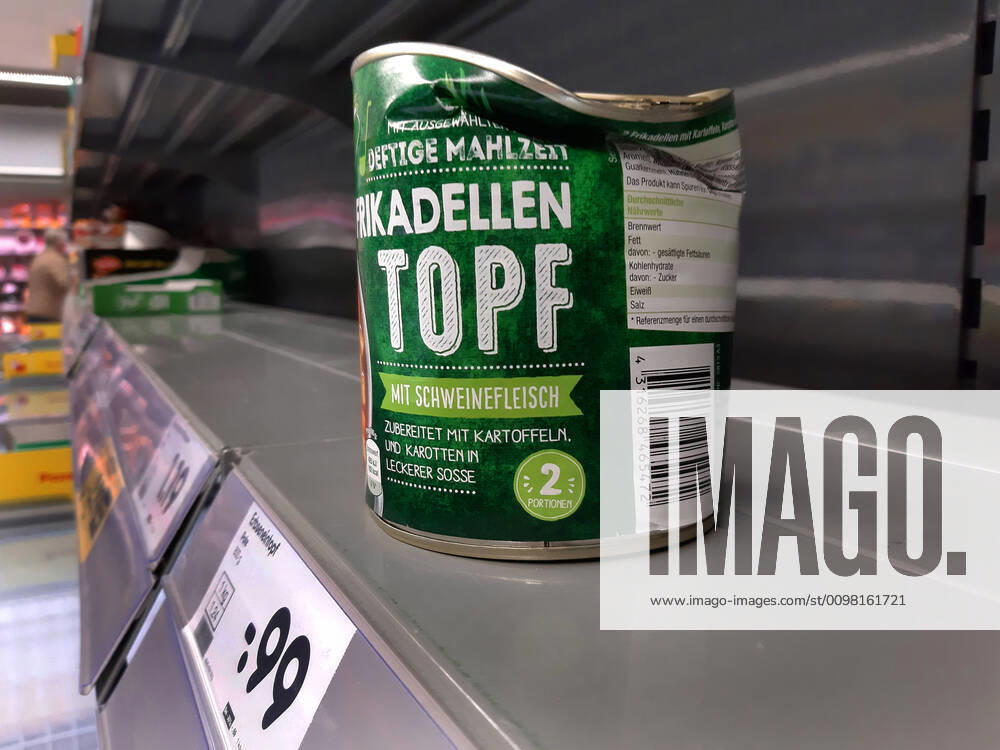 Shopping in a supermarket in Duesseldorf Dented tin can in an empty shelf Shopping