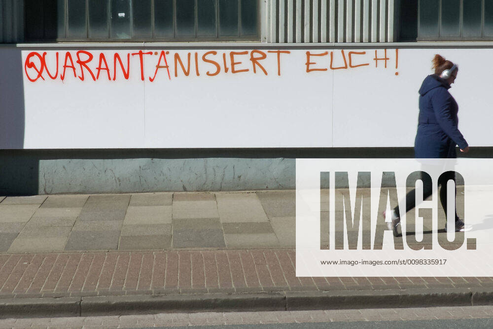 To contain the coronavirus, business closures have been ordered and curfews are being discussed, the photo shows a pedestrian in front of a graffiti, lettering on a building with the inscription Quarantine yourself, 22 03 2020, Bremen Germany , News, Feature, Coronavirus Bremen