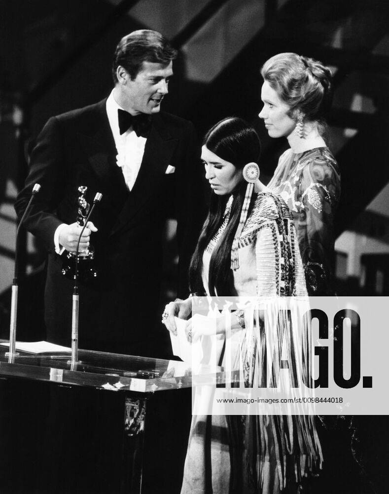 From left, Roger Moore, Sacheen Littlefeather, (aka Maria Cruz), Liv Ullmann, as Littlefeather turns down Marlon Brando s THE GODFATHER Oscar, March 27, 1973 Courtesy Everett Collection !ACHTUNG AUFNAHMEDATUM GESCHÄTZT! PUBLICATIONXNOTxINxCANxCHNxFRAxITAxJPNxNORxPOLxRUSxESPxUKxUSA
