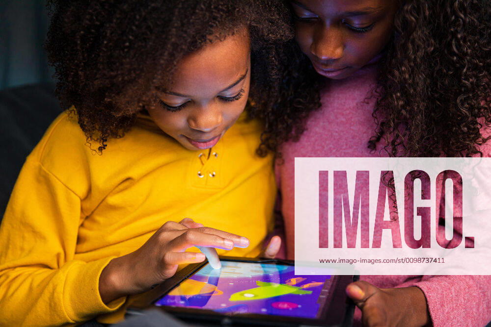 Sisters playing video game on digital tablet at home New York, NY, United States ,model released, Symbolfoto CR_LIWEEE200227-318408-01
