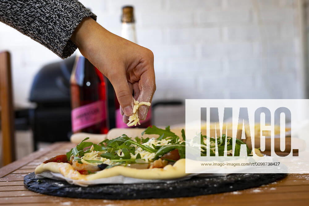 Hand throwing cheese into a vegetarian pizza. Barcelona, CT, Spain ,model released, Symbolfoto CR_EAFU200302A-318044-01