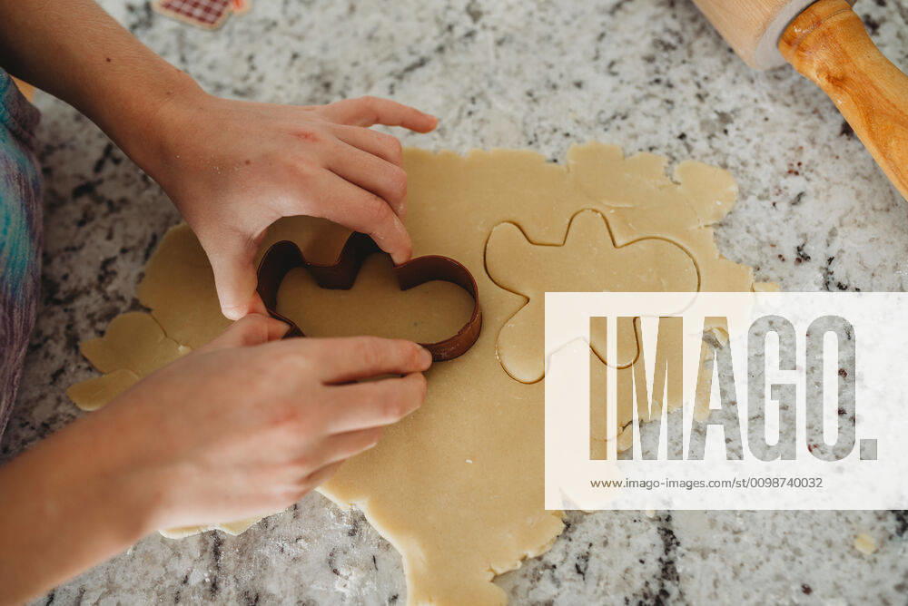 Overview of girl hands cutting out a cookie with cookie cutter Massapequa, NY, United States ,model released, Symbolfoto CR_ERBU200304-318435-01