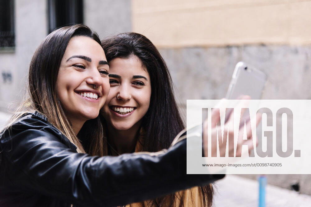 Beautiful Lesbian Couple Taking A Self Portrait At The Street. LGBT. Madrid, Community of Madrid, Spain ,model released, Symbolfoto CR_DAES200306-320636-01