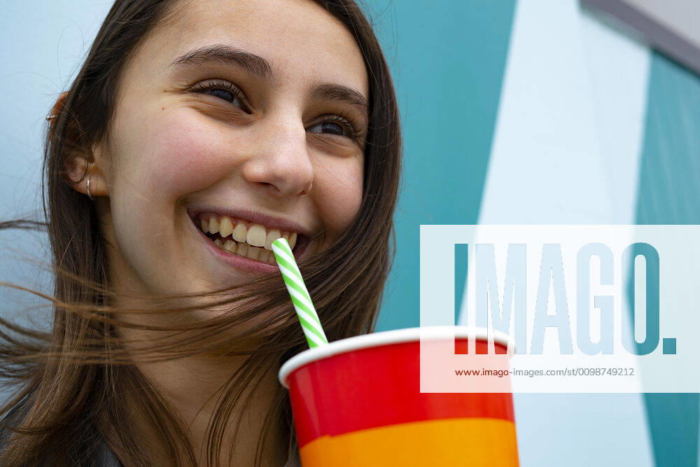 Woman smiling and drinking soda with a straw at a party. Barcelona, CT, Spain ,model released, Symbolfoto CR_EAFU200313B-322757-01